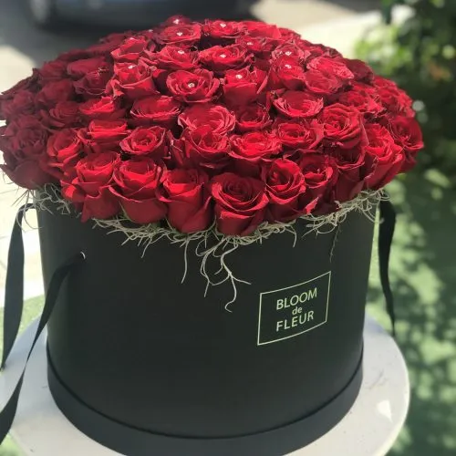 Красные розы в черной шляпной коробке